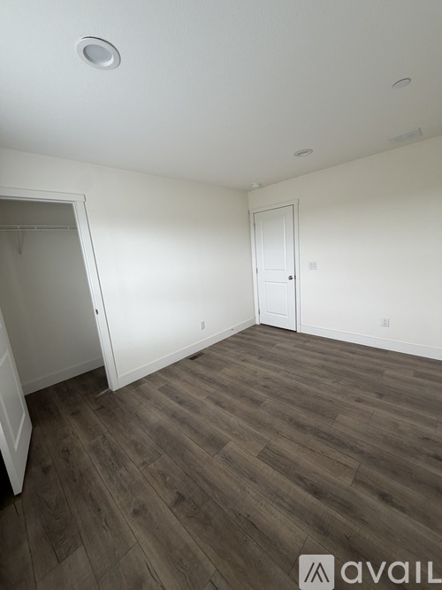 A room with wooden flooring and white walls.