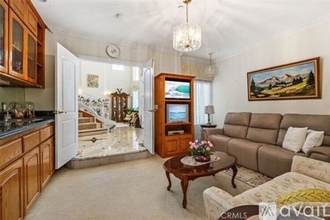 A living room with a couch, coffee table, and a painting on the wall.