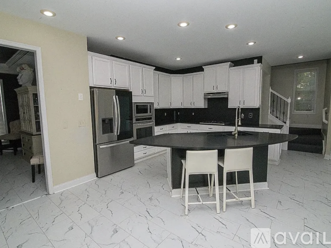 A kitchen with a black countertop and white cabinets.