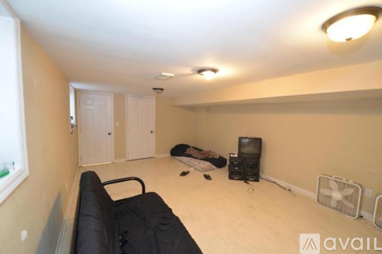 A living room with a black couch and a television.