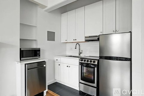 A kitchen with white cabinets and stainless steel appliances.