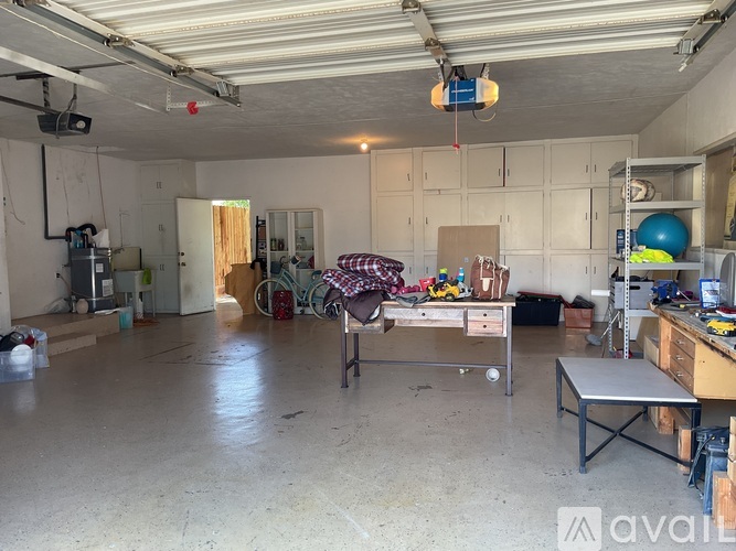 A sparsely furnished room with a workbench and exercise equipment.