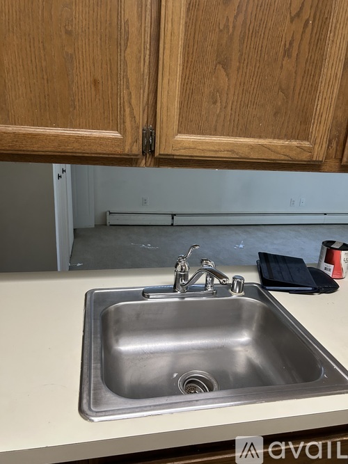 A kitchen sink with a faucet and a black cloth on the counter.