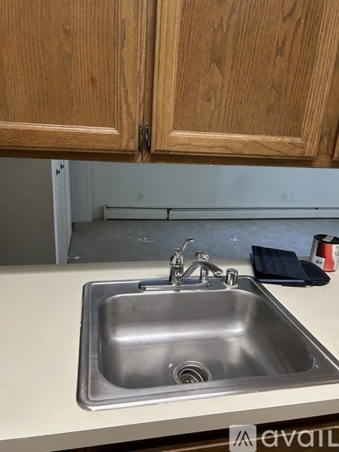 A kitchen sink with a faucet and a black cloth on the counter.