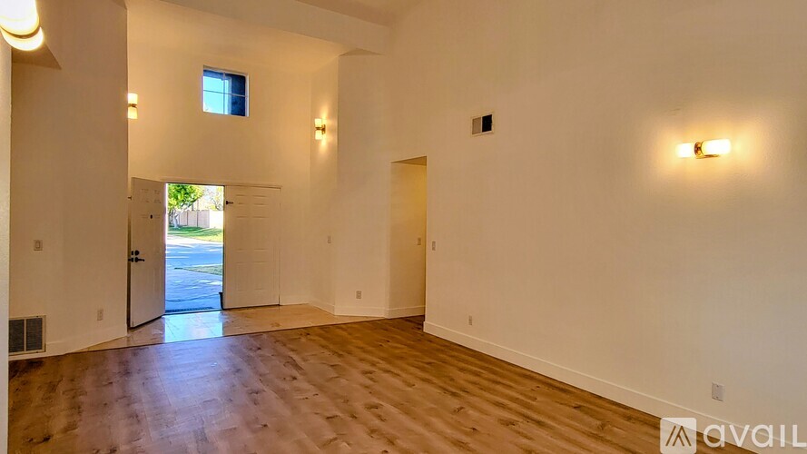 A room with wooden floors and a window overlooking a street.