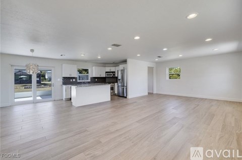 A spacious kitchen with white cabinets and a large island.