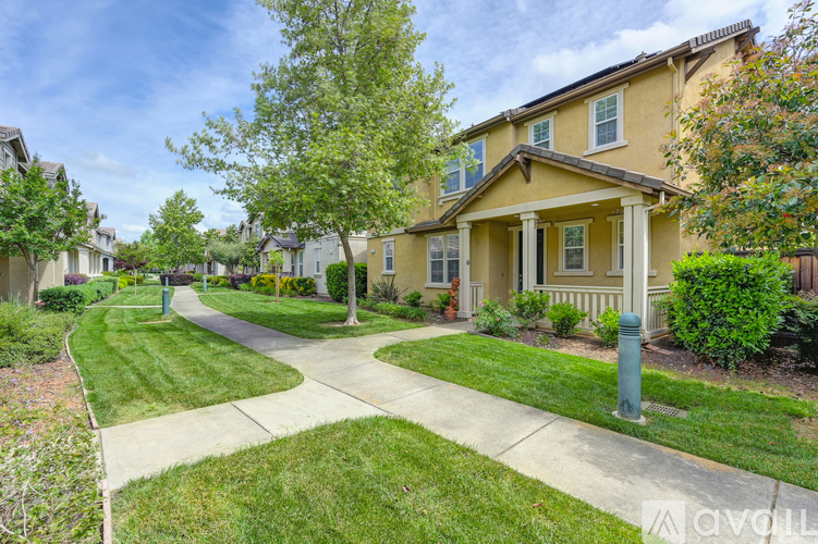 A yellow house with a green lawn in front.
