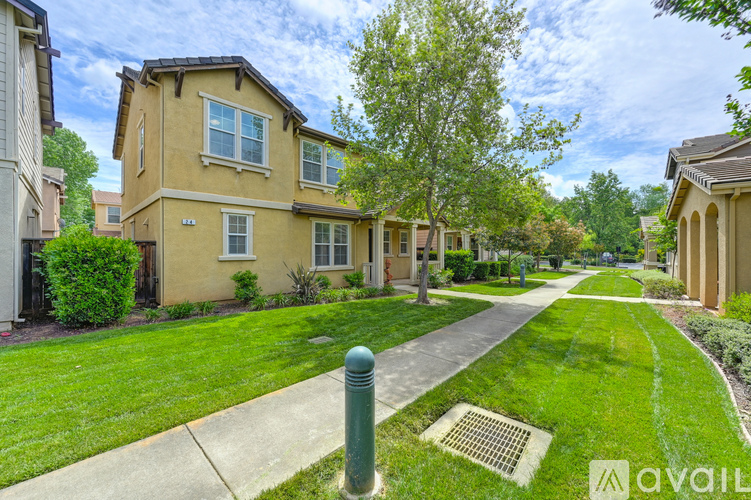 A house with a green lawn and a tree in front of it.