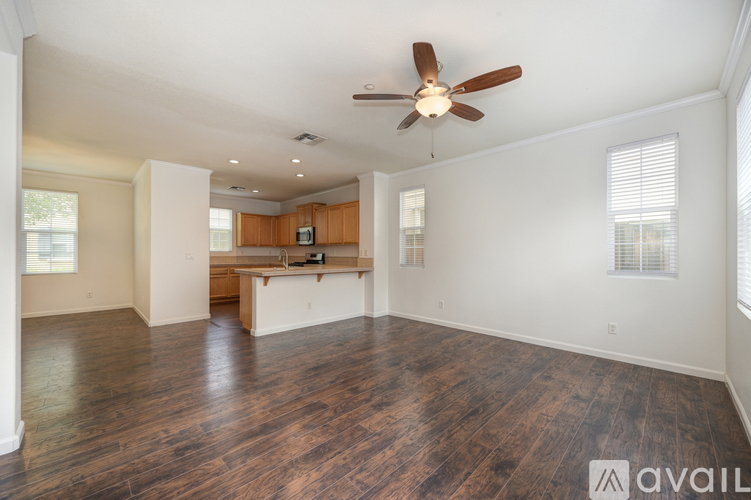 A spacious room with a ceiling fan and wooden flooring.