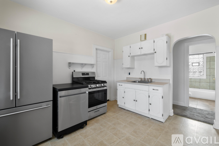 A kitchen with a refrigerator, stove, and sink.