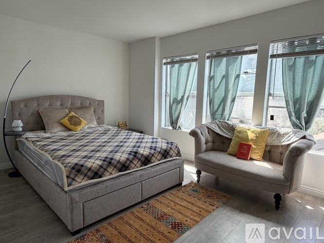 A bedroom with a bed and a chair.