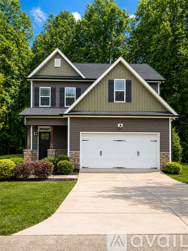A house with a grey roof and a white garage door.
