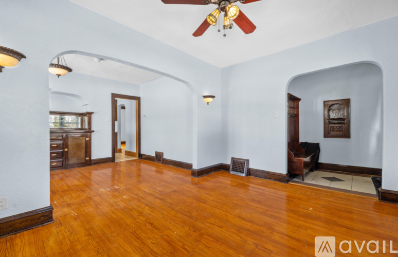 A room with a ceiling fan and wooden floors.