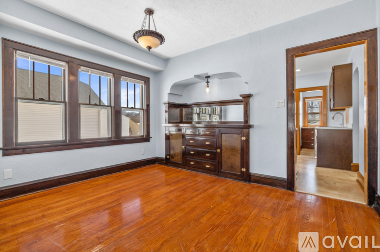 A room with wooden floors and a large wooden cabinet.