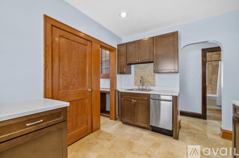 A kitchen with wooden cabinets and a stainless steel dishwasher.