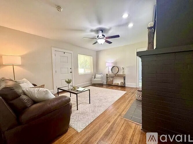 A living room with a brown couch and a ceiling fan.