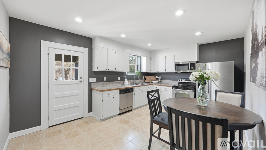 A modern kitchen with a dining table set for two.