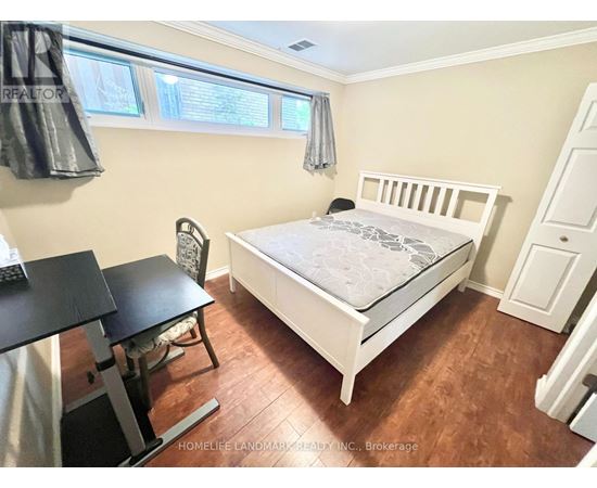 A bedroom with a white bed and a black desk.