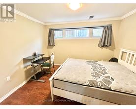 A bedroom with a bed, desk, and chair.