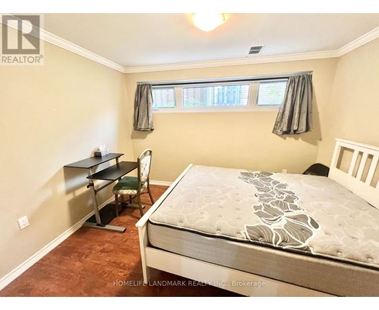A bedroom with a bed, desk, and chair.