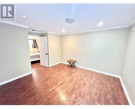 A room with wooden flooring and a ceiling light fixture.