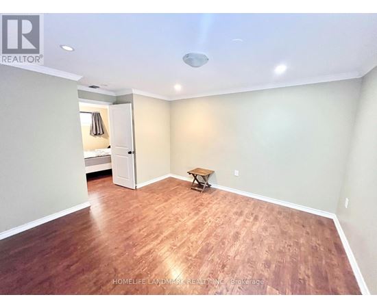 A room with wooden flooring and a ceiling light fixture.