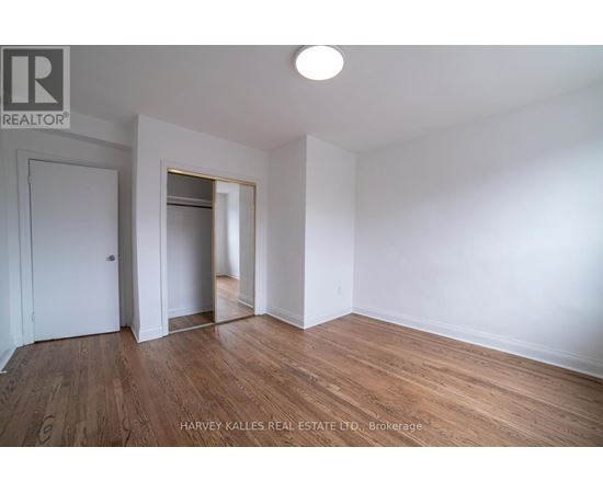 A spacious kitchen with wooden flooring and stainless steel appliances.