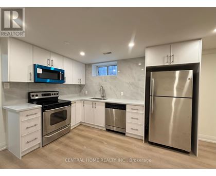 A kitchen with white cabinets and a stainless steel refrigerator.