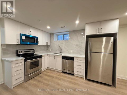 A kitchen with white cabinets and a stainless steel refrigerator.