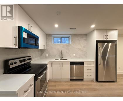 A kitchen with white cabinets and a blue microwave.