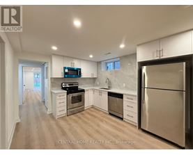 A modern kitchen with stainless steel appliances and white cabinets.