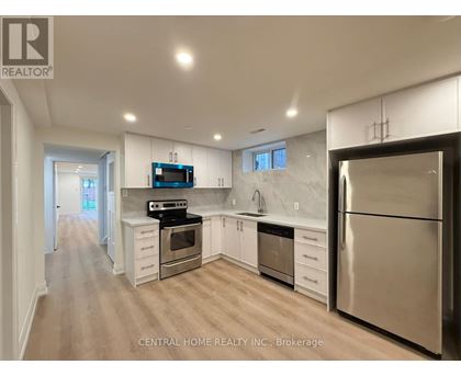 A modern kitchen with stainless steel appliances and white cabinets.