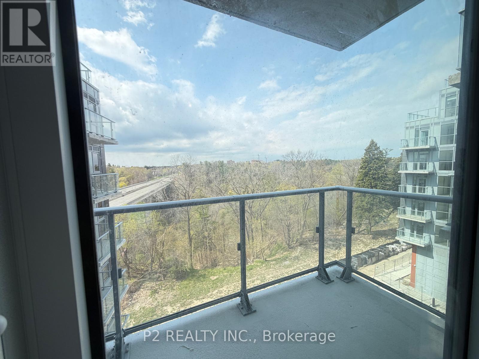 A balcony with a view of a road and trees.