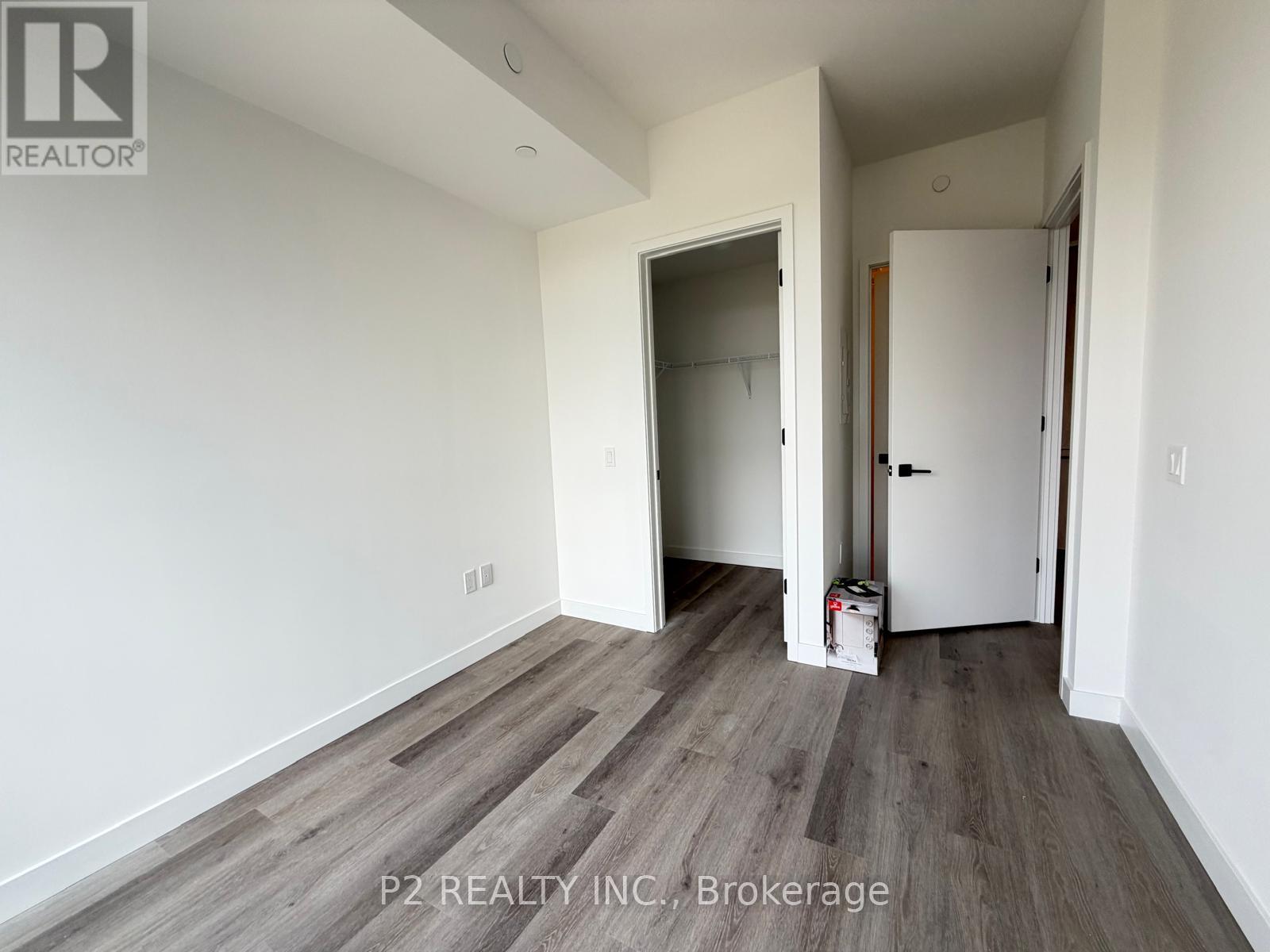 A room with a white wall and a wooden floor.