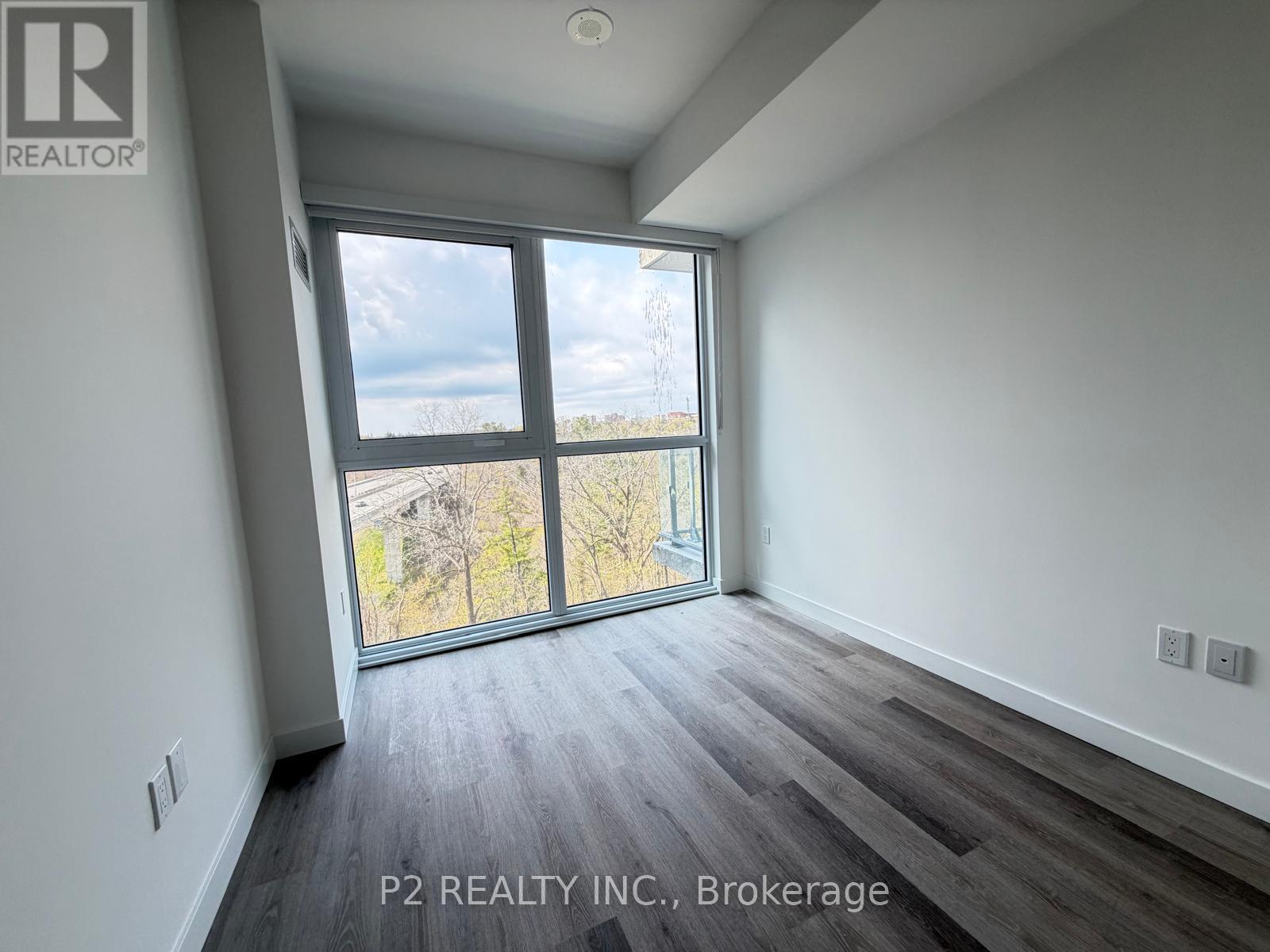 A room with a large window and wooden flooring.