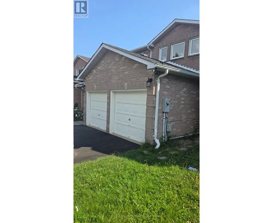 A house with a white garage door and a brick wall.