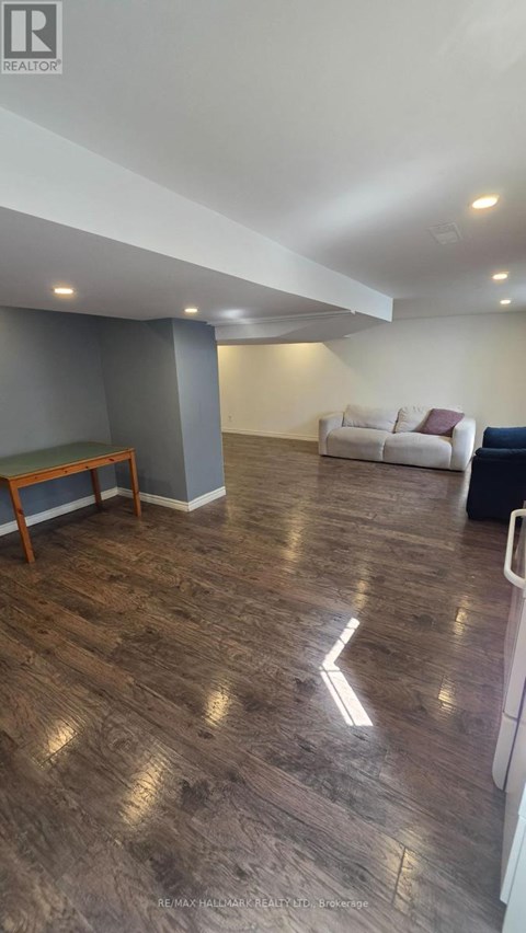 A living room with a white couch and a wooden bench.