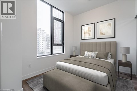 A bedroom with a large bed and two framed pictures on the wall.