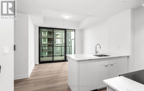 A white kitchen with a sink and a window.
