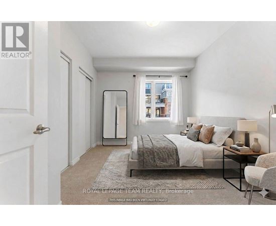 A bedroom with a bed, chair, and a window.