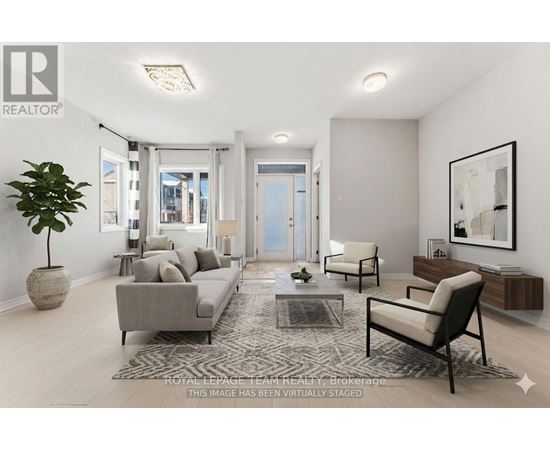 A living room with a grey couch, a black chair, and a rug.