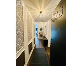 A hallway with a light fixture and a number 323 on the wall.