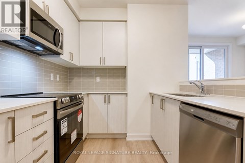 A kitchen with white cabinets and a black stove top oven.