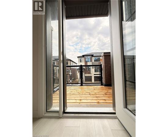 A view from inside a building looking out through a glass door at a residential area.