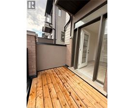 A wooden deck with a glass door leading to a balcony.