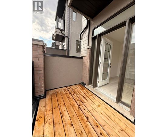 A wooden deck with a glass door leading to a balcony.
