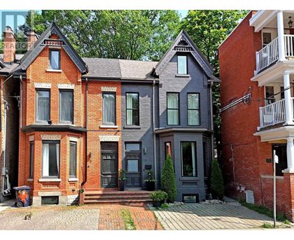 A red brick house with a grey house next to it.