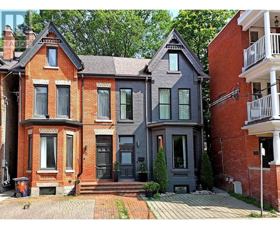 A red brick house with a grey house next to it.