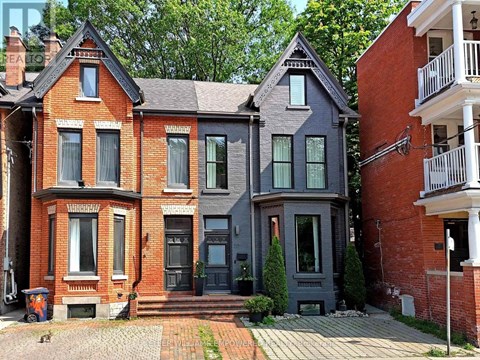 A red brick house with a grey house next to it.