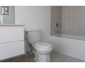 A white toilet in a bathroom with a bathtub and a shower.